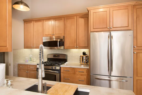 a kitchen with stainless steel appliances granite countertop a refrigerator and a sink