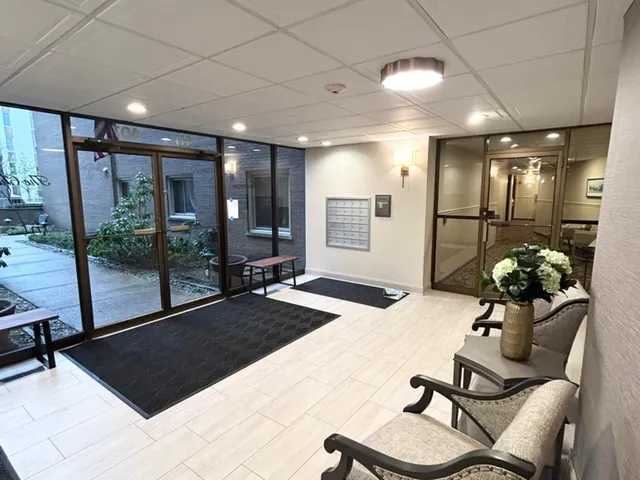 a view of a hallway with wooden floor and a couch