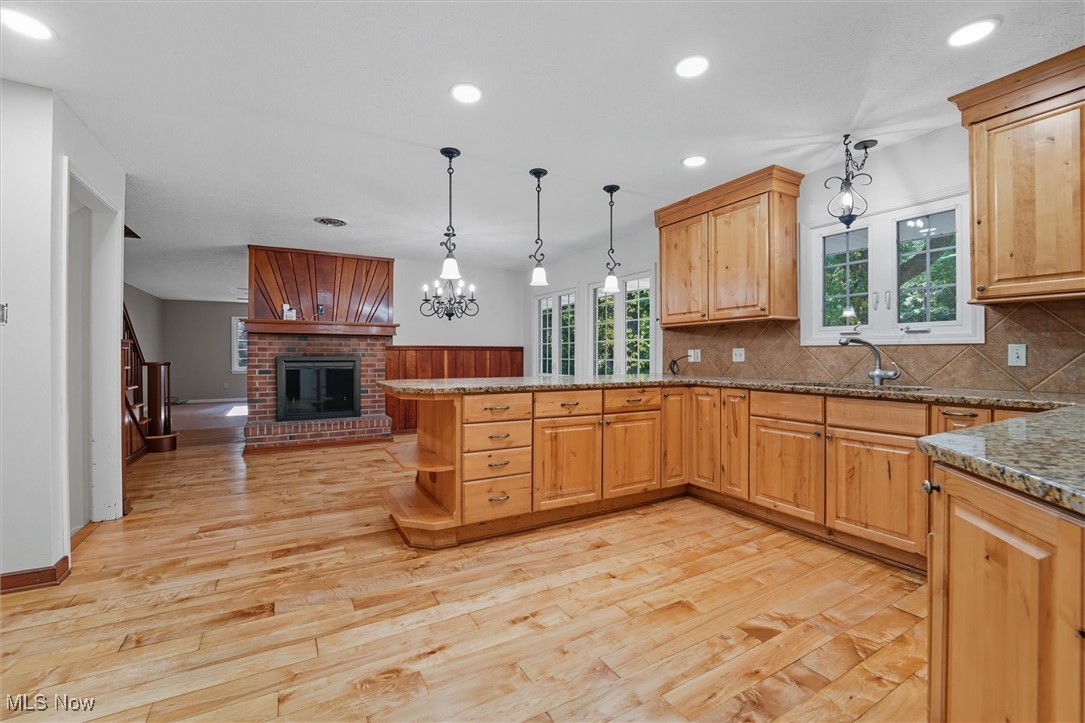 11884 Frost Road Mantua, OH 44255 - Photo 5 of 42 Kitchen featuring decorative backsplash, hanging light fixtures, a peninsula, recessed lighting, and light wood flooring