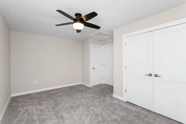 an empty room with a ceiling fan and windows