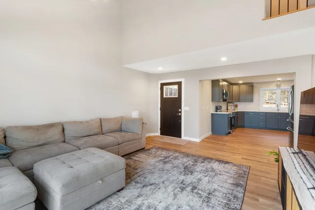 a living room with furniture and a dining table with kitchen view