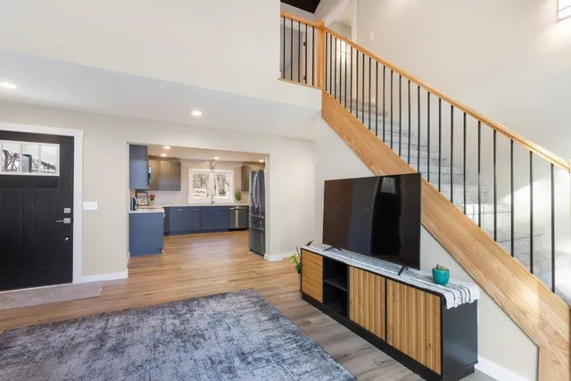 a view of a hallway with wooden floor and flat screen tv