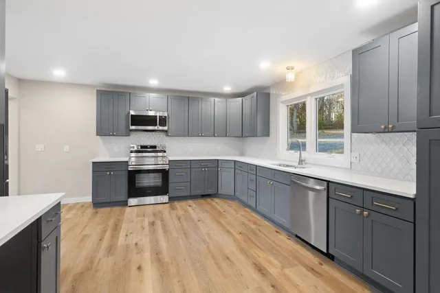 a kitchen with stainless steel appliances kitchen island granite countertop a stove sink and cabinets