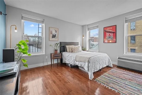 a spacious bedroom with a bed table and a window