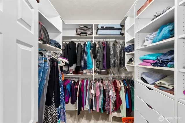 a view of walk in closet with clothes
