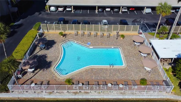 a view of a patio with a table chairs and a swimming pool