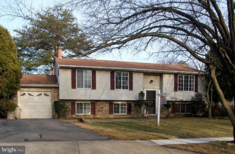 a front view of a house with a large tree