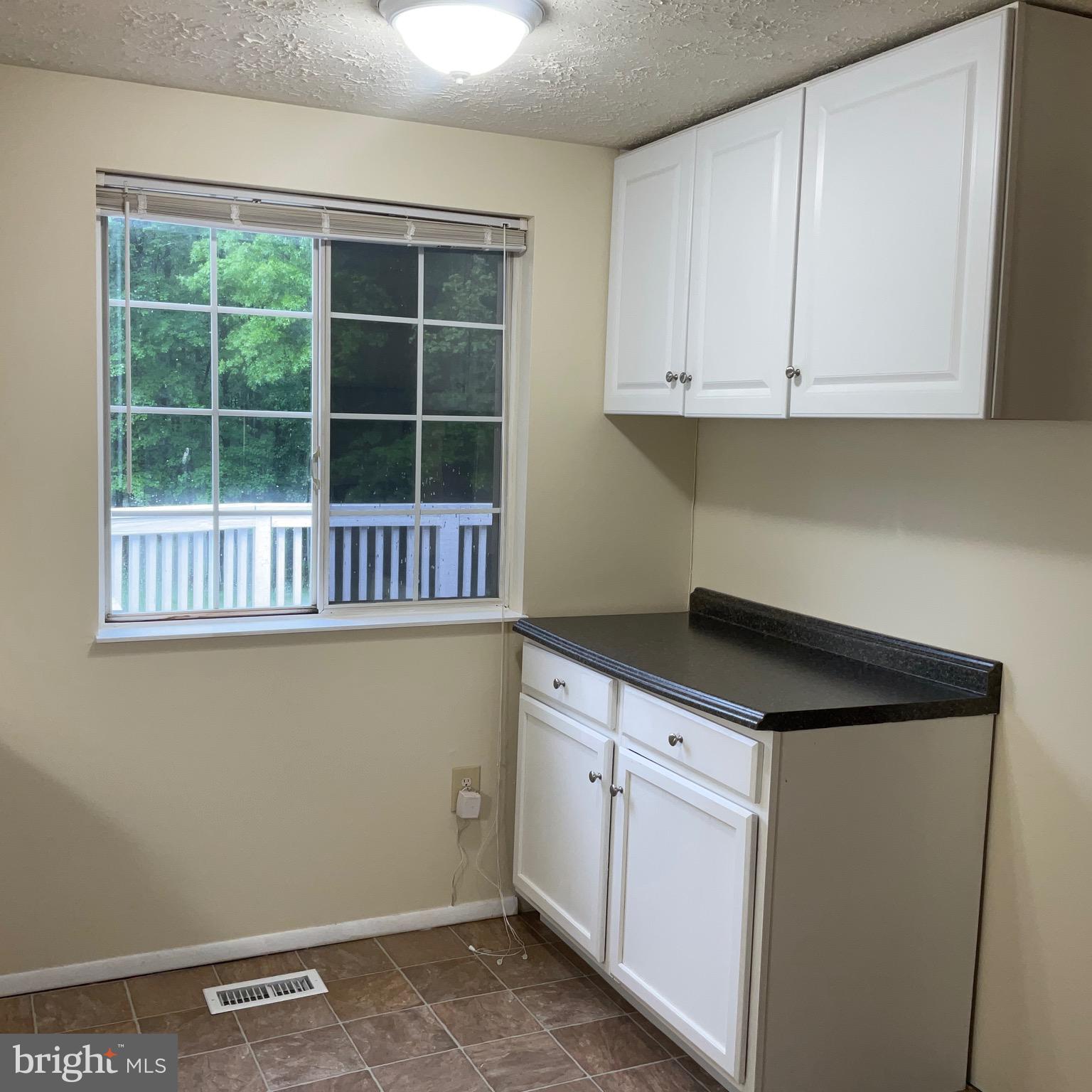 9218 Briarchip Street Laurel, MD 20708 - Photo 18 of 38 a kitchen with granite countertop white cabinets and a refrigerator