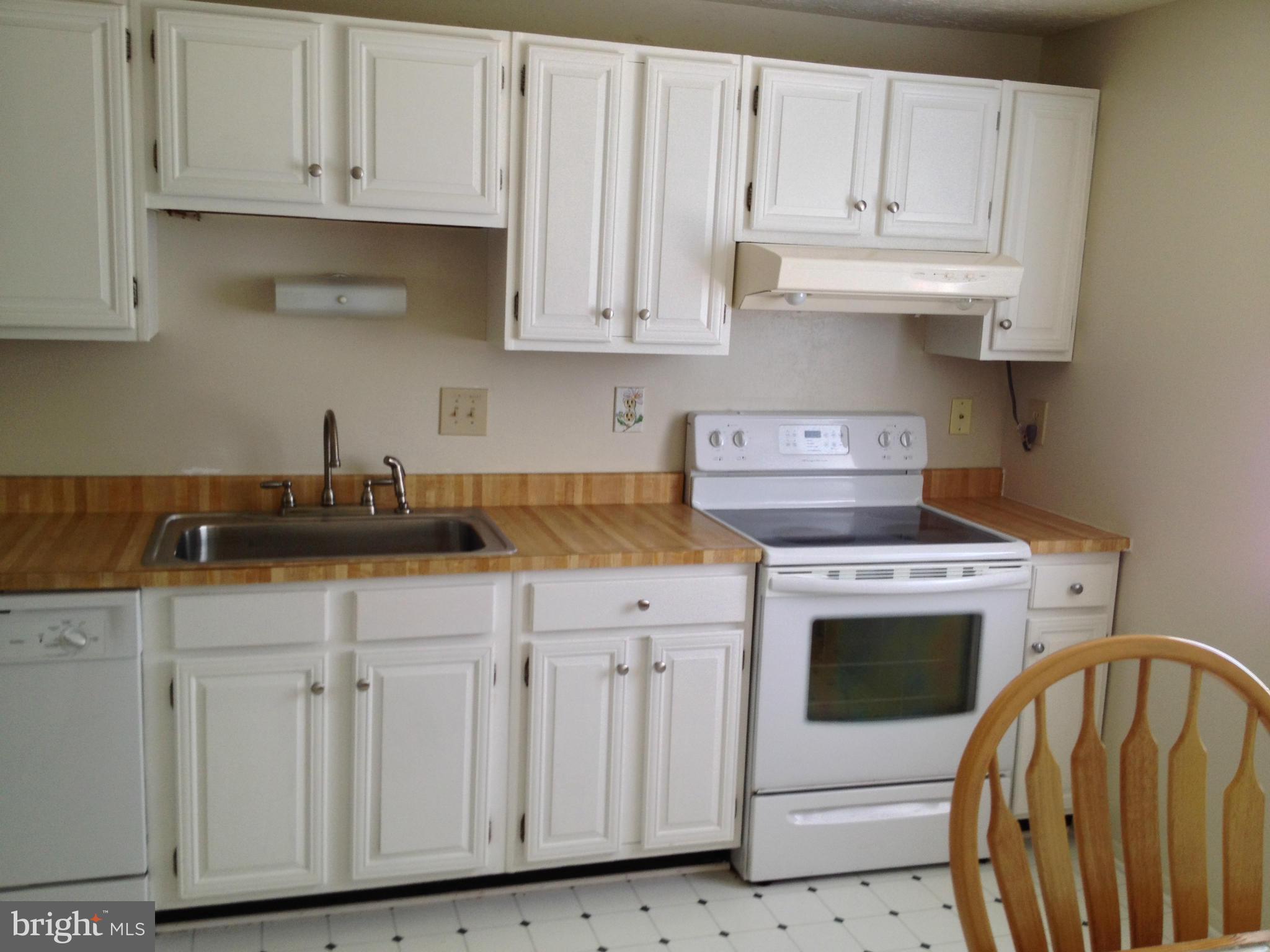 9218 Briarchip Street Laurel, MD 20708 - Photo 4 of 38 a kitchen with white cabinets and white appliances
