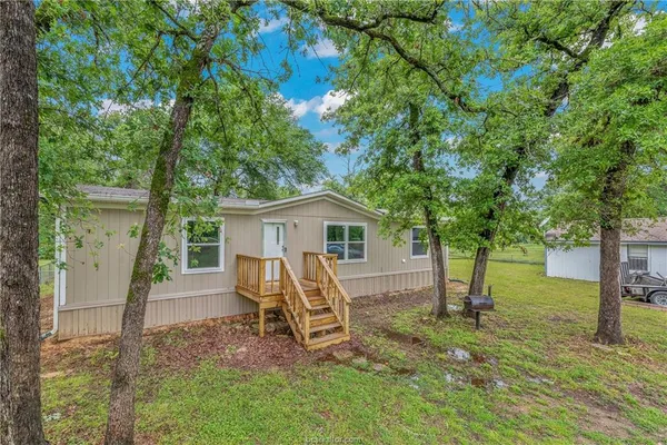 a view of a house with a yard and tree s