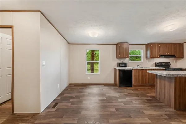 a kitchen with granite countertop a stove a sink and a refrigerator