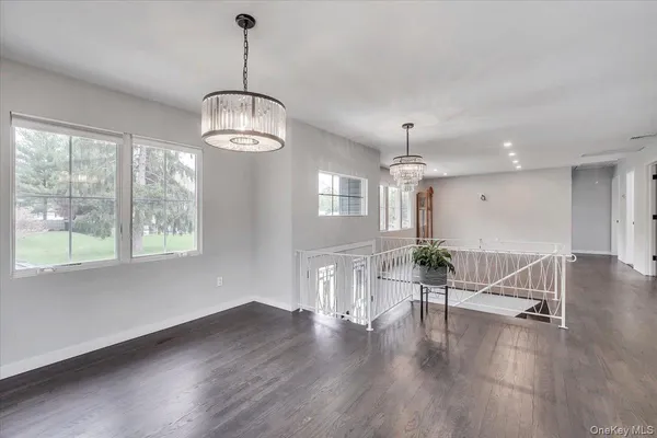 a view of a livingroom with wooden floor windows and a chandelier