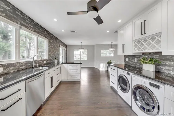 a view of a kitchen with stainless steel appliances granite countertop a sink and cabinets