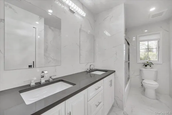 a bathroom with a sink double vanity and a toilet