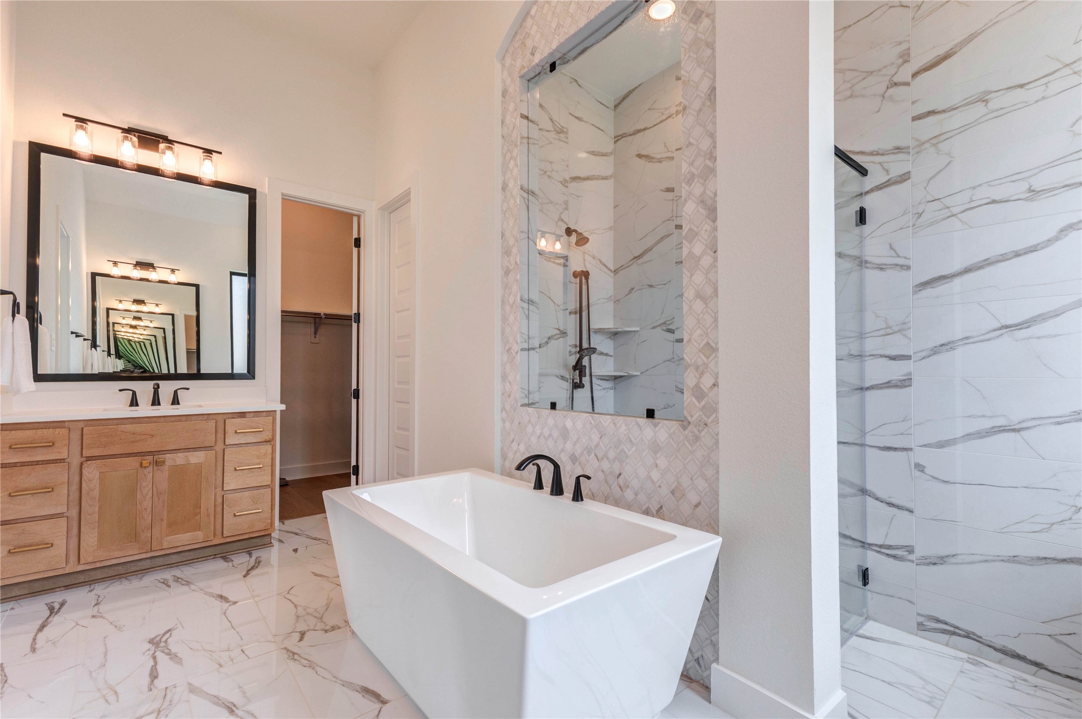 a spacious bathroom with a bathtub sink and mirror