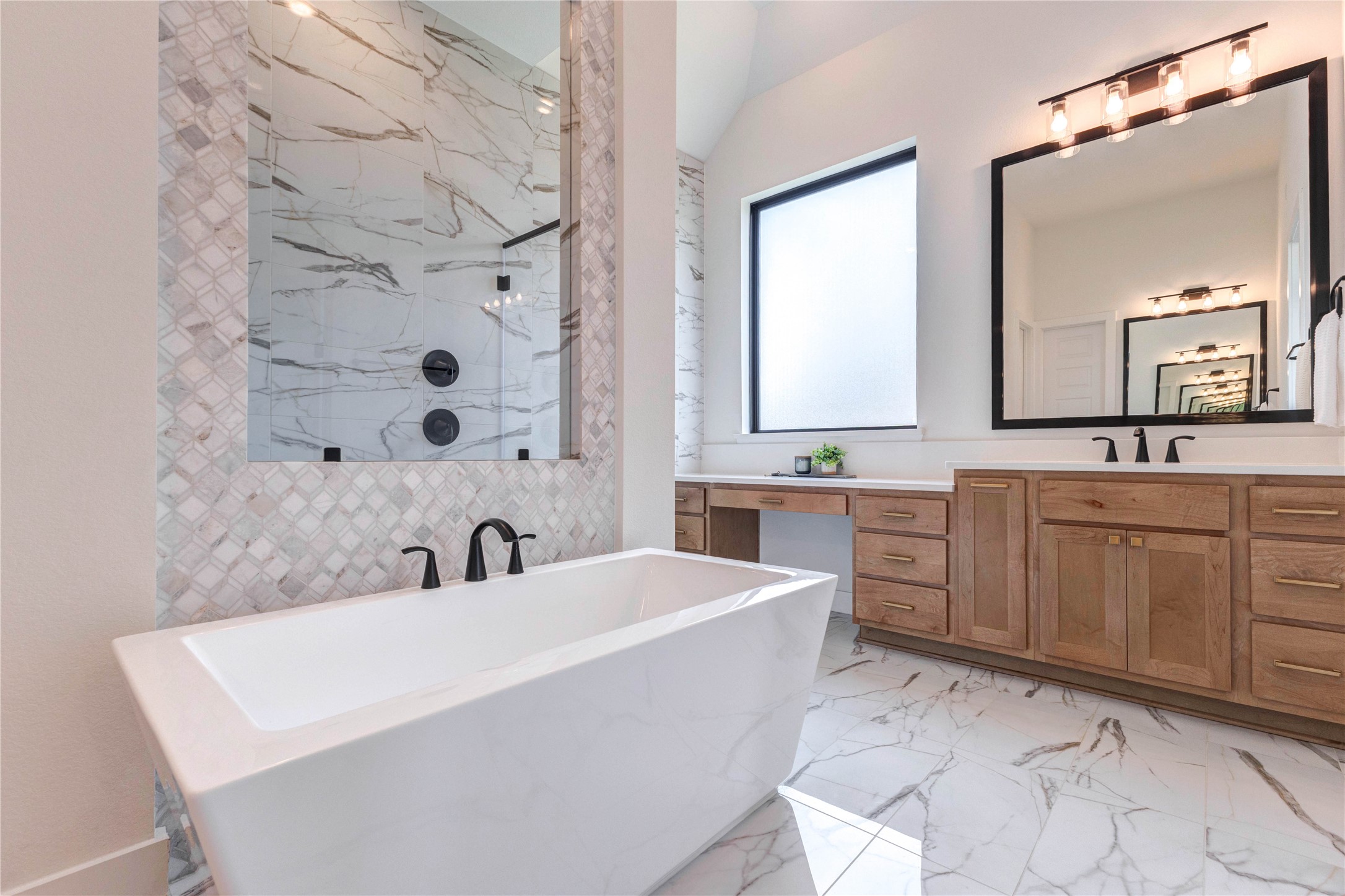 4510 Windmill Lndg Lane Fulshear, TX 77441 - Photo 33 of 48 This bathroom features a modern freestanding tub, elegant marble-patterned tiles, and a spacious glass-enclosed shower. It also includes a sleek vanity with ample natural light from a large window.