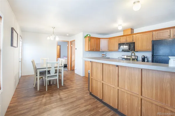 a kitchen with stainless steel appliances granite countertop a table chairs sink and cabinets