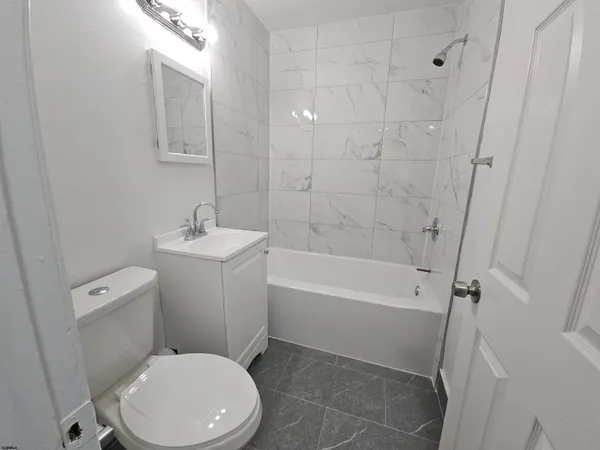 a white toilet sitting next to a bath tub