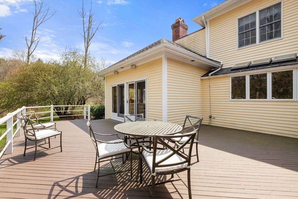 114 Farm Street Dover, MA 02030 - Photo 36 of 40 a view of a roof deck with table and chairs and wooden floor