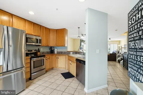 a kitchen with granite countertop a refrigerator and a stove top oven
