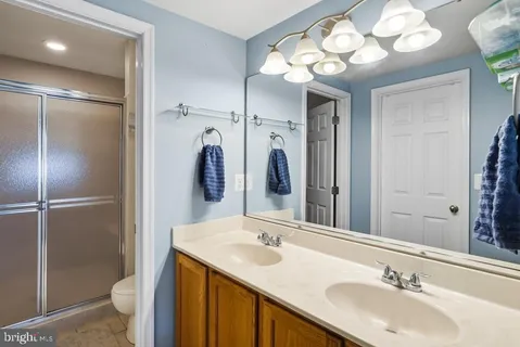 a bathroom with a sink vanity granite toilet and a mirror