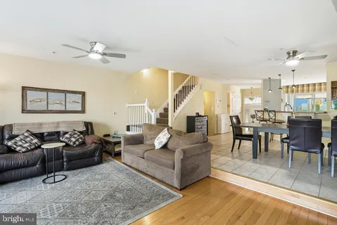 a living room with furniture kitchen view and a chandelier
