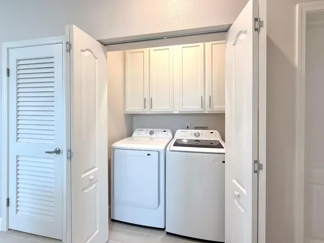 a view of an empty room with wooden floor and windows