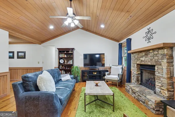 a living room with furniture a flat screen tv and a fireplace