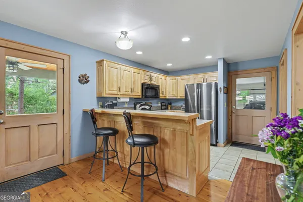 a kitchen with stainless steel appliances granite countertop sink refrigerator and microwave