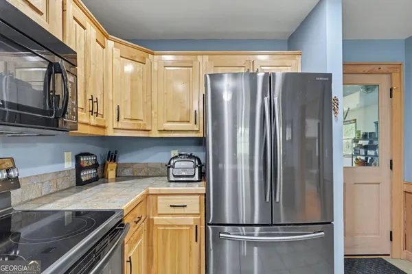 a kitchen with stainless steel appliances granite countertop a refrigerator and a sink