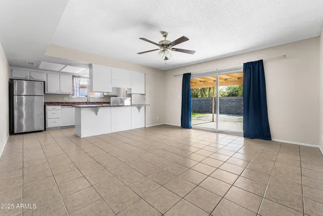a large white kitchen with a stove a sink dishwasher and a refrigerator with wooden floor