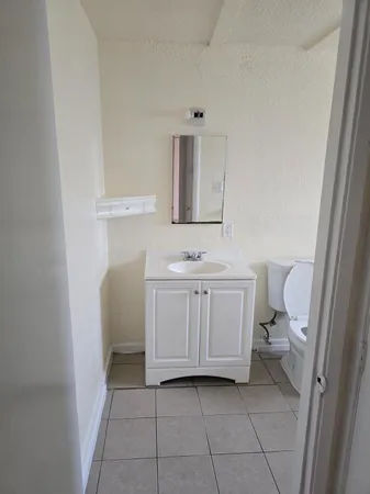 a bathroom with a sink a toilet and mirror