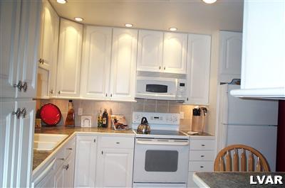 19 Balson Road Stroudsburg, PA 18360 - Photo 2 of 17 a kitchen with stainless steel appliances granite countertop a stove a sink dishwasher and white cabinets with wooden floor