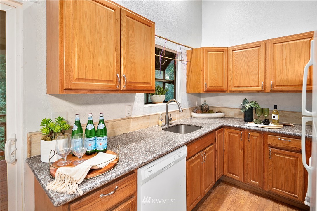 18433 126th Place Southeast Renton, WA 98058 - Photo 11 of 22 a kitchen with stainless steel appliances granite countertop a sink a stove and a microwave