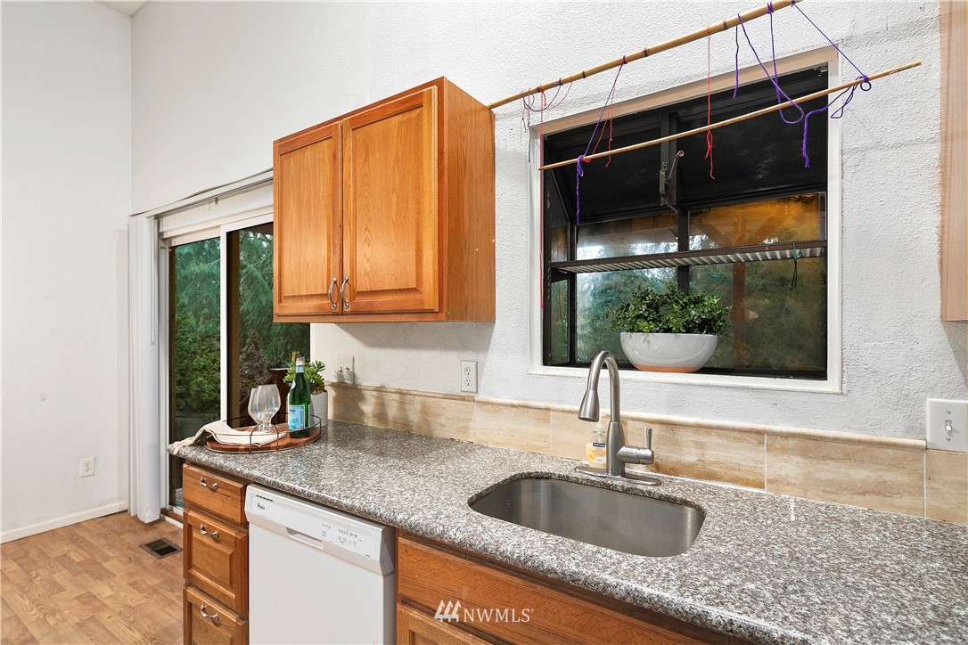 18433 126th Place Southeast Renton, WA 98058 - Photo 13 of 22 a kitchen with granite countertop a sink and a window