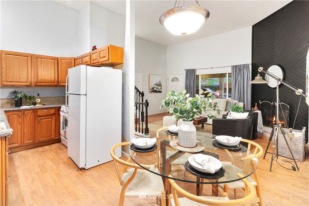 18433 126th Place Southeast Renton, WA 98058 - Photo 9 of 22 a kitchen with stainless steel appliances granite countertop a refrigerator a stove a microwave oven with a dining table and chairs