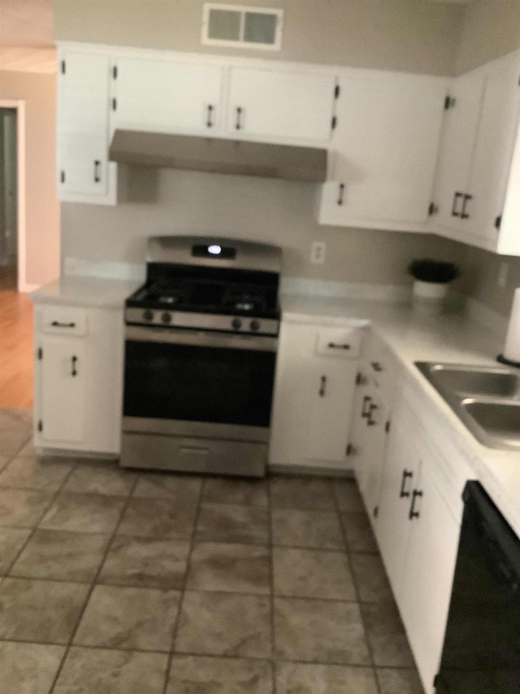4179 Riche Road Memphis, TN 38128 - Photo 5 of 14 Kitchen featuring white cabinetry, black dishwasher, tile patterned flooring, stove, and sink