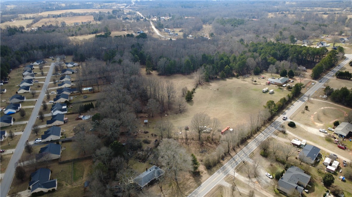 6980 Midway Road Pelzer, SC 29669 - Photo 3 of 15 An aerial perspective reveals a serene rural landscape with scattered homes and verdant expanses.