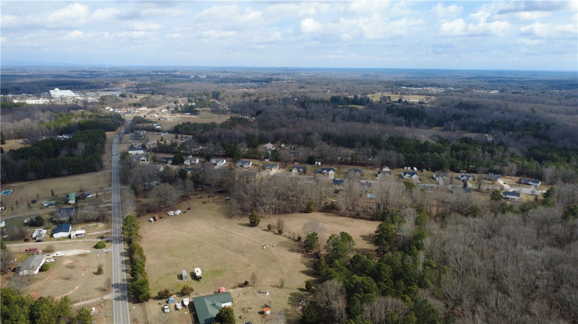 6980 Midway Road Pelzer, SC 29669 - Photo 6 of 15 An aerial perspective reveals a vast landscape with wooded areas and scattered residential properties.