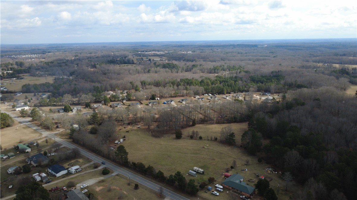 6980 Midway Road Pelzer, SC 29669 - Photo 7 of 15 Vast natural landscapes extend under a dynamic sky, offering endless possibilities for development.