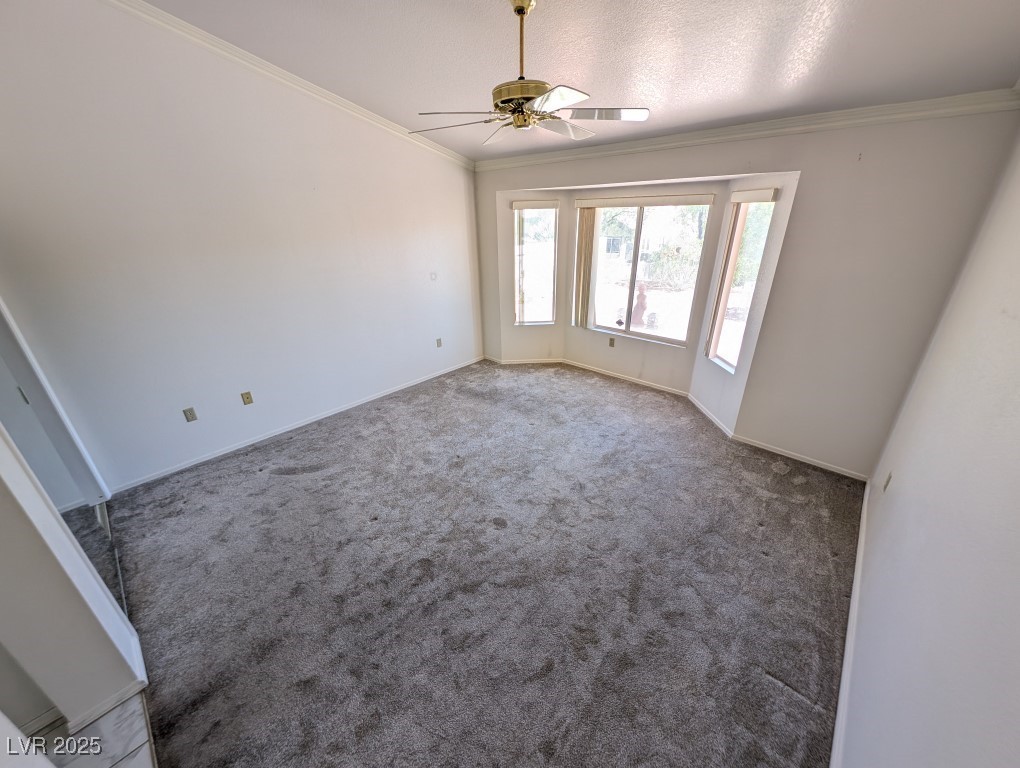 2504 Sunup Drive Las Vegas, NV 89134 - Photo 11 of 27 Unfurnished room featuring ornamental molding, carpet flooring, a ceiling fan, and a textured ceiling