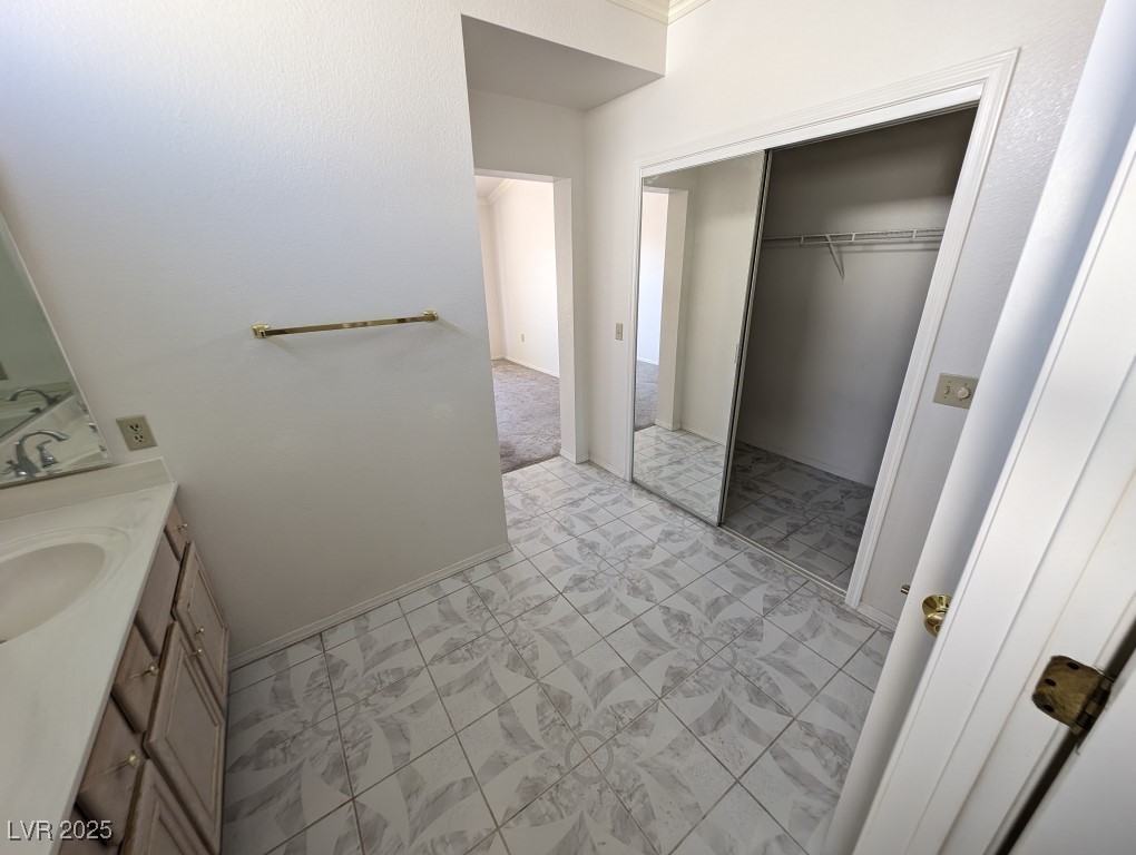 2504 Sunup Drive Las Vegas, NV 89134 - Photo 16 of 27 Bathroom featuring vanity, a spacious closet, and ornamental molding
