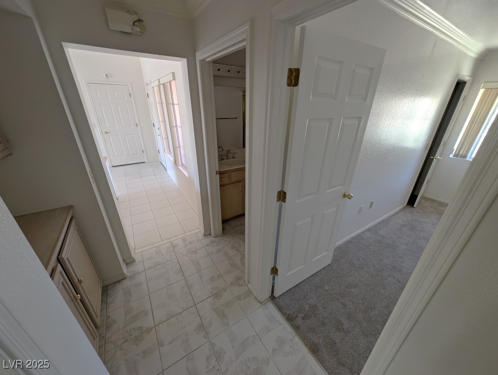 2504 Sunup Drive Las Vegas, NV 89134 - Photo 18 of 27 Corridor with crown molding, light colored carpet, and light tile patterned floors