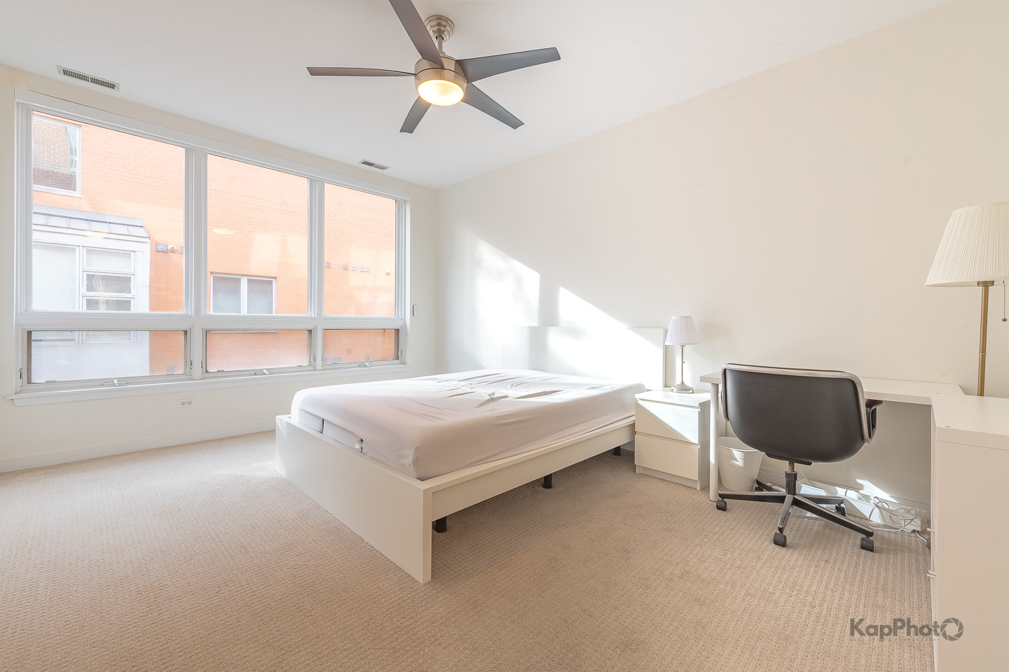 1151 West Washington Boulevard, Unit 125 Chicago, IL 60607 - Photo 20 of 28 a bedroom with a bed a chair and a large window