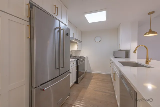 a kitchen with white cabinets and stainless steel appliances