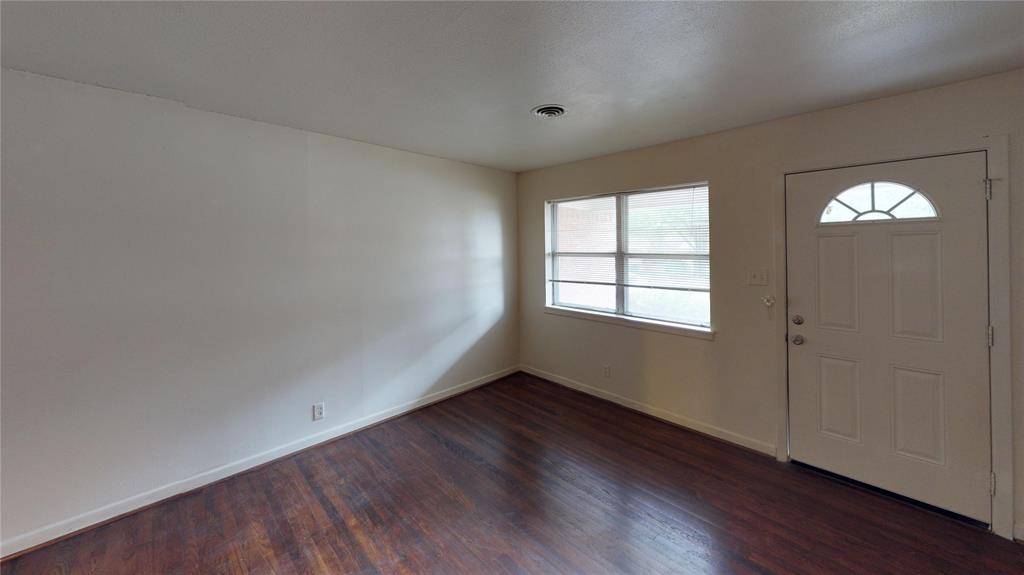 1705 Crescent Street Denton, TX 76201 - Photo 3 of 7 an empty room with wooden floor and windows