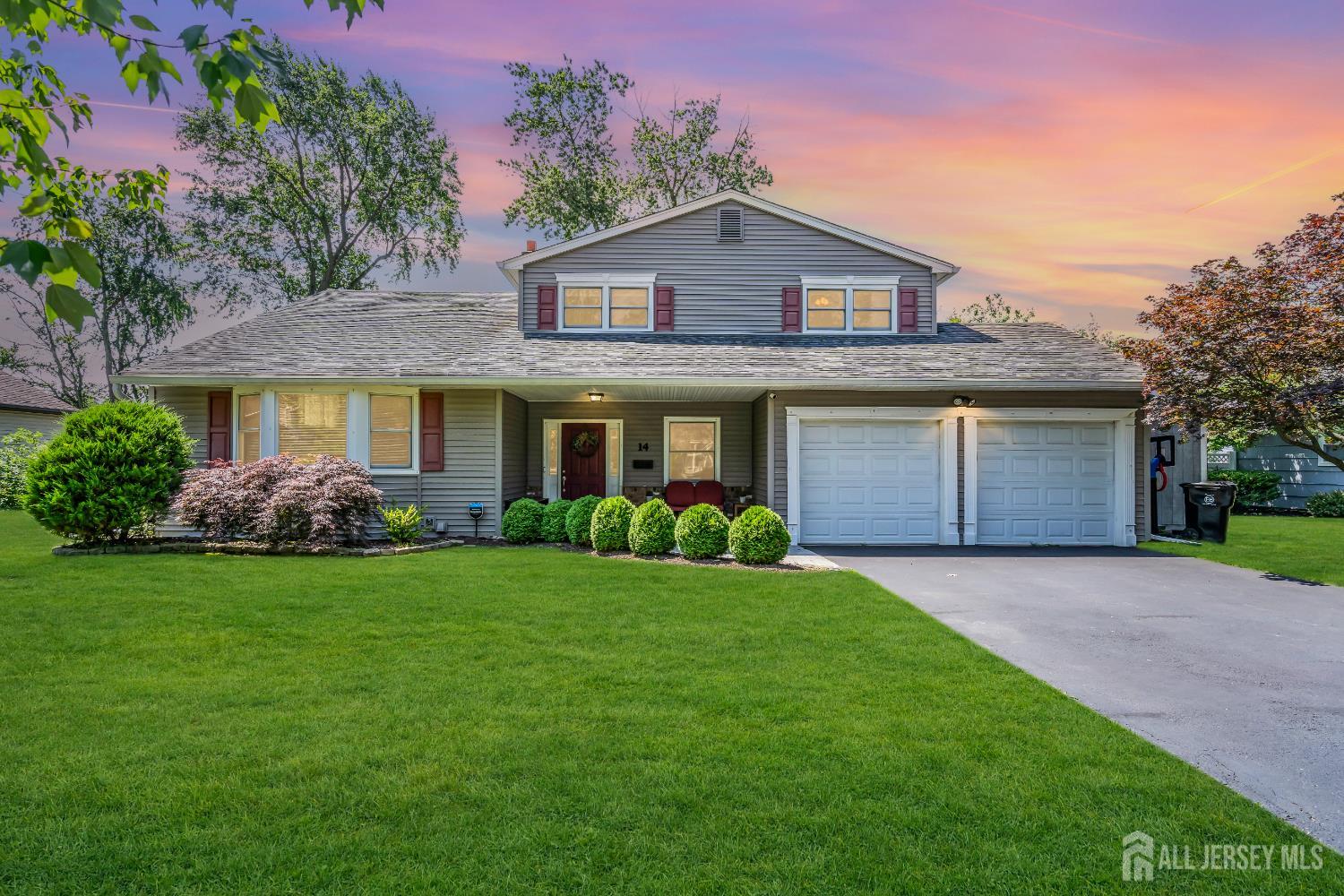 a front view of a house with a garden and yard