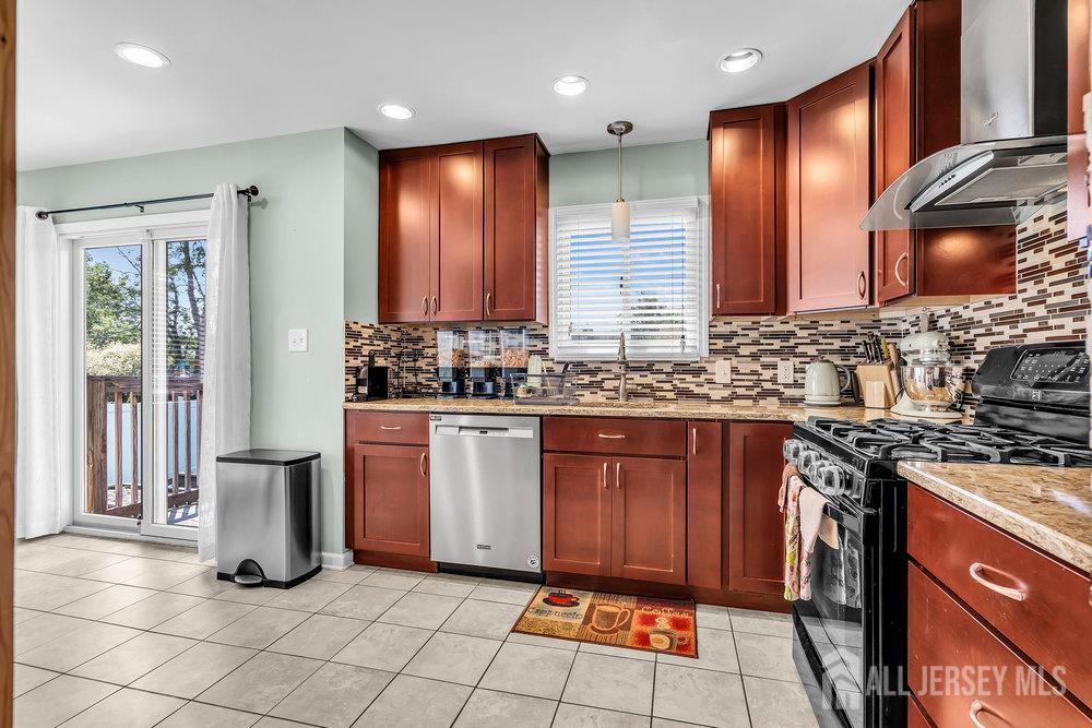 14 Academic Road East Brunswick, NJ 08816 - Photo 11 of 28 a kitchen with stainless steel appliances granite countertop a stove a sink and a refrigerator