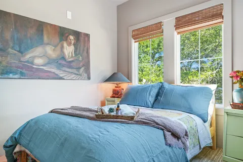 a bed sitting in a bedroom next to a window