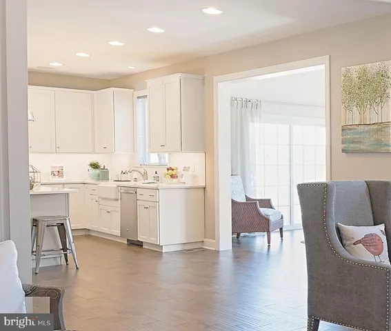 a kitchen with white cabinets and chairs